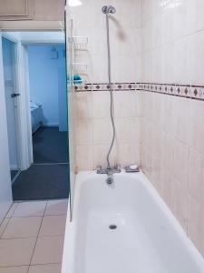 een badkamer met een bad en een douche bij Grosvenor court in Londen