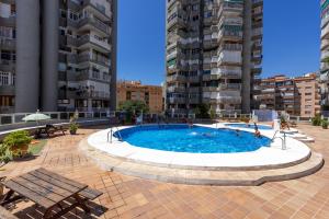 a pool in the middle of a city with buildings at Apt Playa y Montaña in Torremolinos