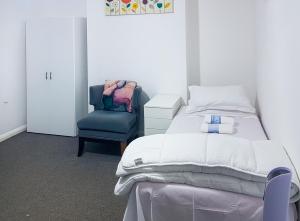 1 dormitorio con 1 cama y 1 silla azul en Grosvenor court en Londres