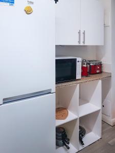 een keuken met een witte koelkast en een magnetron bij Grosvenor court in Londen