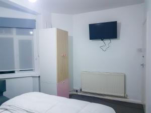 a bedroom with a bed and a tv on the wall at Grosvenor court in London