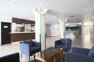 eine Lobby mit Stühlen und einem Tisch in einem Gebäude in der Unterkunft Hotel D. Luis in Coimbra