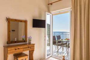 A television and/or entertainment centre at Pool Apartments with panoramic sea view - Pelekas Beach, Corfu