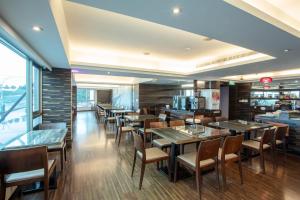 a dining room with tables and chairs in a restaurant at 觀海樓海景大飯店 Hotel Cloud Riverside in Tamsui