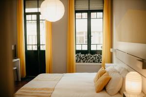 a bedroom with a bed and two windows at H.ö.H in Porto