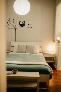 een slaapkamer met een bed met een uilenblad aan de muur bij H.ö.H in Porto