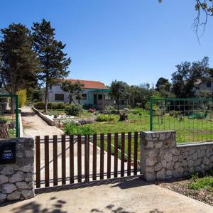 une porte en bois dans une cour avec une maison dans l'établissement Beach House Wild Paradise, à Silba