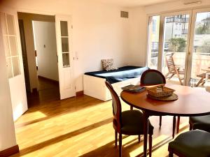 a living room with a table and a room with a balcony at Villa Médicis Trouville-sur-mer in Trouville-sur-Mer +13 photos