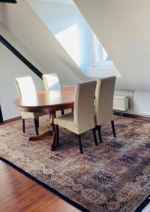 mesa de comedor con sillas y alfombra en Charmante Ferienwohnung mit Kaminofen, en Bremerhaven
