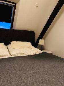 a bedroom with a bed with a black headboard and a window at Charmante Ferienwohnung mit Kaminofen in Bremerhaven