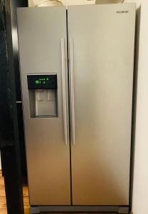 a stainless steel refrigerator with an ice box at Charmante Ferienwohnung mit Kaminofen in Bremerhaven