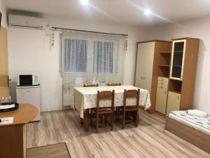 a kitchen and dining room with a table and chairs at Balaton Panzió in Balatonberény