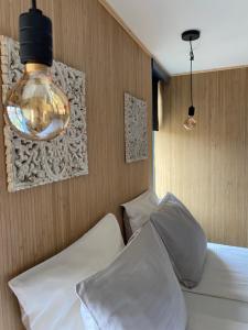 1 Schlafzimmer mit 2 weißen Betten und einer Leuchte in der Unterkunft Hotel Buren in West-Terschelling