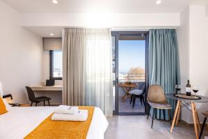 レティムノ・タウンにあるLines Concept Accommodationのベッド、テーブル、椅子が備わるホテルルームです。