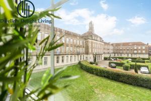 a large brick building with cars parked in a yard at Dagenham - Dwellers Delight Living Ltd Services Accommodation - Greater London , 2 Bed Apartment with free WiFi & secure parking in Dagenham