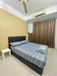 a bedroom with a bed and a table in it at Comfy Sutera Seberang Jaya in Kampong Belah Dua