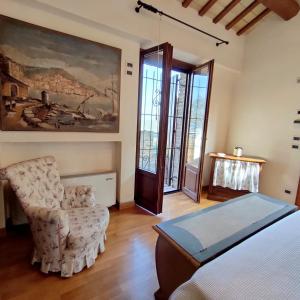 1 dormitorio con 1 cama, 1 silla y 1 pintura en Villa Adele Senigallia, en Senigallia