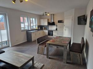 a living room with a table and a kitchen at DM Hotels & Apartments - Apartment Rasenweg in Dingelstädt
