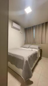 een kleine slaapkamer met een bed en een raam bij Flat Porto Blue 104 Centro Porto de Galinhas in Porto De Galinhas