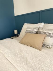 2 camas blancas en un dormitorio con una pared azul en Gólyafészek Vendégház, en Egerszalók