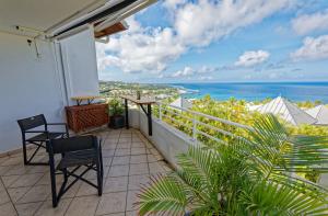 a balcony with two chairs and a view of the ocean at L'Eden Blue à Saint Gilles les Bains, magnifique vue mer in Saint-Gilles les Bains