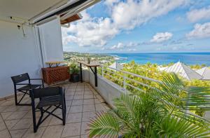 ein Balkon mit zwei Stühlen und Blick auf das Meer in der Unterkunft L'Eden Blue à Saint Gilles les Bains, magnifique vue mer in Saint-Gilles-les-Bains