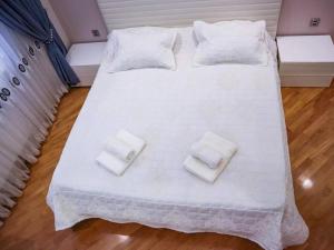 a large white bed with two white towels on it at Explore Baku from YSB Apartment in Baku