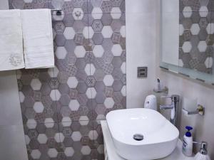 a bathroom with a white sink and a mirror at Explore Baku from YSB Apartment in Baku +8 photos