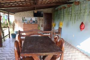 a dining room with a wooden table and chairs at Barra Adventure Pousada in Mataraca