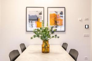 una sala da pranzo con tavolo e vaso di fiori di Petrin Tower Residence a Praga