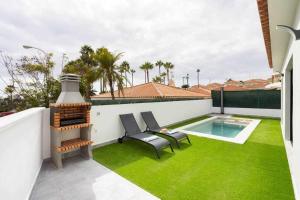 a patio with green grass and a swimming pool at Sunny Island Villa Sueño Azul in Callao Salvaje