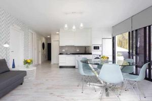 a white kitchen with a dining table and chairs at Sunny Island Villa Sueño Azul in Callao Salvaje