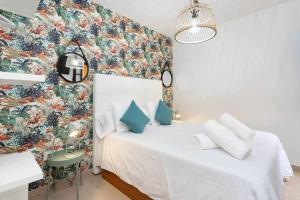 sypialnia z białym łóżkiem i tapetą w kwiaty w obiekcie Sunnyland Apartment Costa Silencio parking w Aronie +37 zdjęć