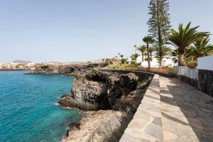 kamienny chodnik nad oceanem z palmami w obiekcie Sunnyland Apartment Costa Silencio parking w Aronie