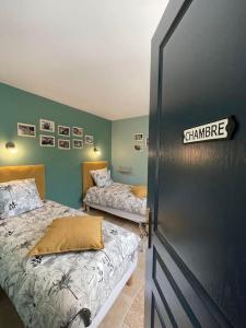 Thenay的住宿－Gîte La Cabuche proche du zoo de Beauval，绿墙客房内的两张床