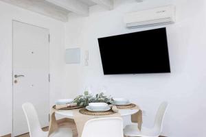a dining room with a table with chairs and a tv at Sunnyland Ático Adelfas San Andrés in San Andrés