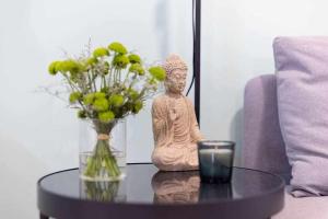 una estatua sobre una mesa con una vela y un jarrón de flores en Sunnyland 1º Adelfas San Andrés, en San Andrés