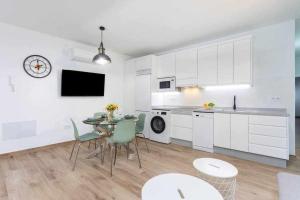 Una cocina con gabinetes blancos y una mesa y sillas. en Sunnyland 1º Adelfas San Andrés, en San Andrés