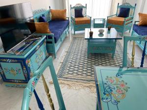 salon z niebieskimi meblami i stołem w obiekcie Marsa Central Splendid Appart 2 w mieście La Marsa