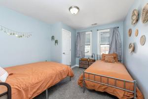 - 2 lits dans une chambre aux murs bleus dans l'établissement Recently renovated 3BR home near Heritage Park!, à Dundalk
