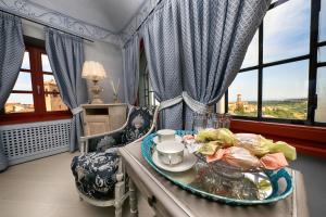 a living room with a table with a plate of food at Relais Villa Prato in Mombaruzzo