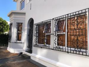 a white house with a wrought iron gate at The Marilyn on Sea Point in Cape Town