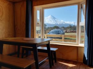 a table and a window with a view of a mountain at OmShanti in Puerto Varas