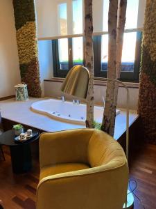 uma sala de estar com uma cadeira amarela e árvores em Mama House, Centro di Catania,Castello, Pescheria, em Catânia