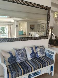 a mirror above a bench in a living room at Villa Carthagene /Jacuzzi -swimingpool- Billard in Sidi Daoud