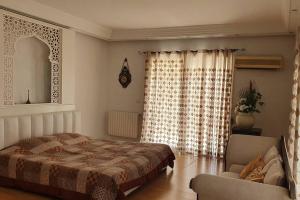 a bedroom with a bed and a chair and a window at Villa Carthagene /Jacuzzi -swimingpool- Billard in Sidi Daoud