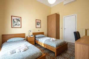 een slaapkamer met 2 bedden en een bureau met een bureau bij LT ATENEO in Bari