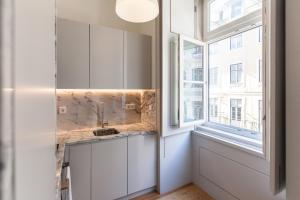 cocina con fregadero y ventana en FLH Downtown Modern Art Flat, en Lisboa