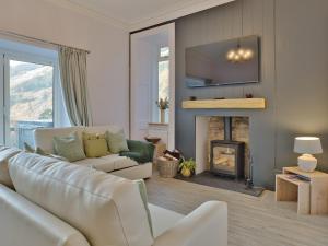 a living room with a couch and a fireplace at Cur Cottage - Uk7809 in Coirantee