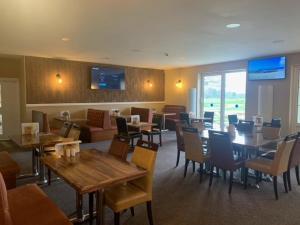 a dining room with tables and chairs and a restaurant at Silverstone Golf Club And Hotel in Silverstone
